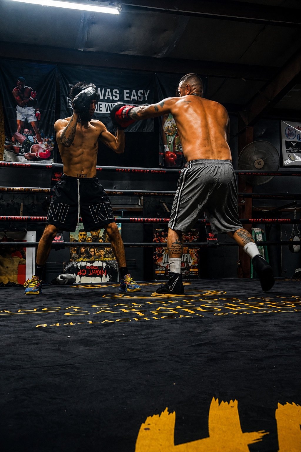Andrew throwing a punch into a training partner's pads in the ring