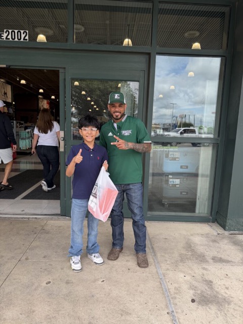 Andrew with a young player outside a store after picking up new gear