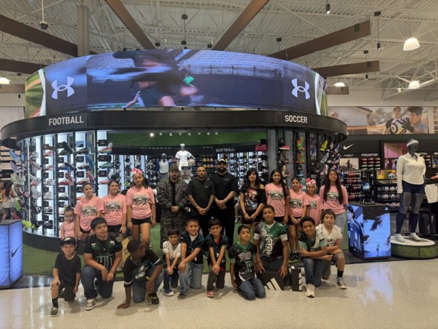 Kids and coaches from the program together at a sporting goods store on cleats day