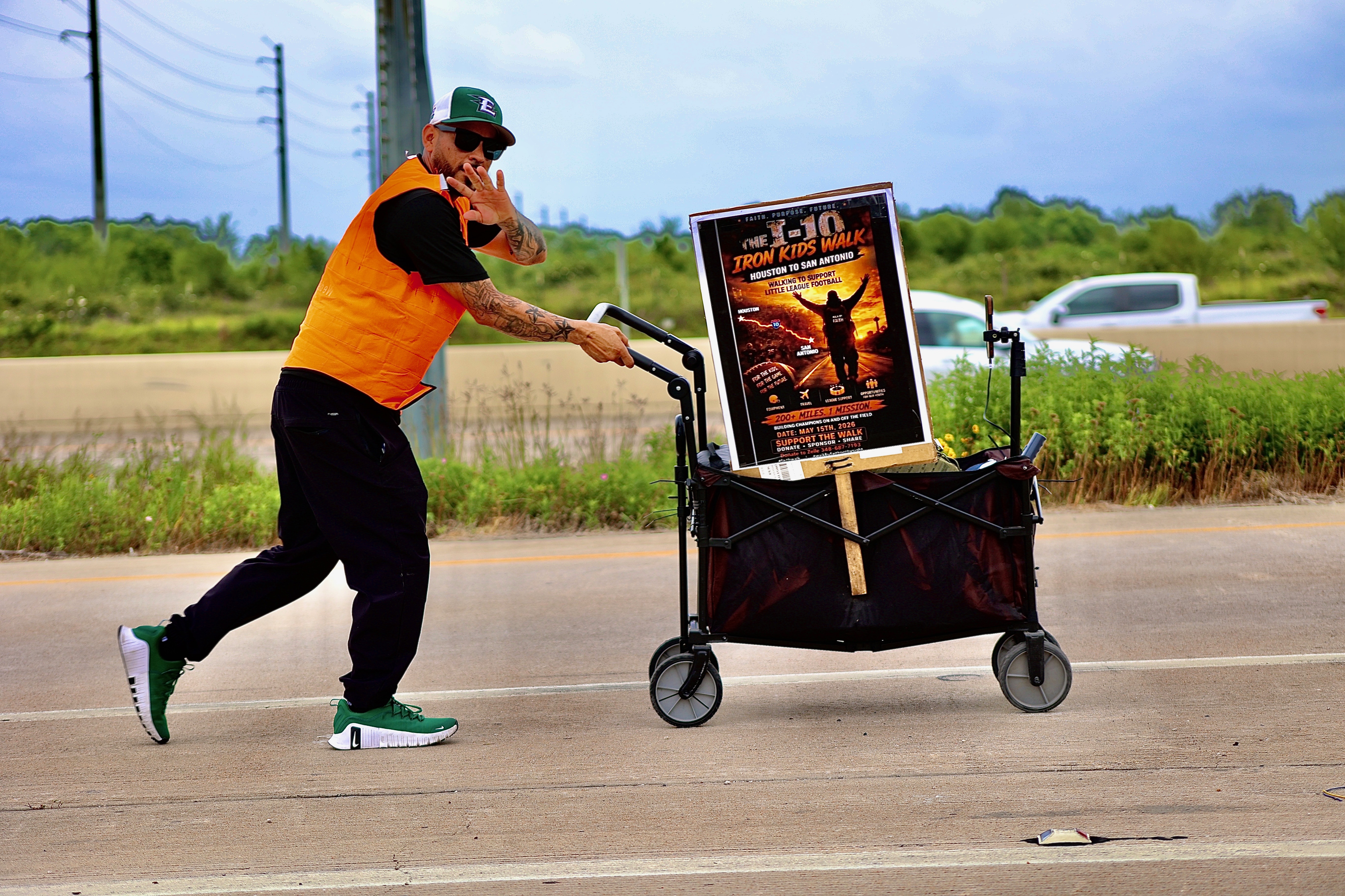 Coach Andrew walking the route with the Iron Kids Walk sign